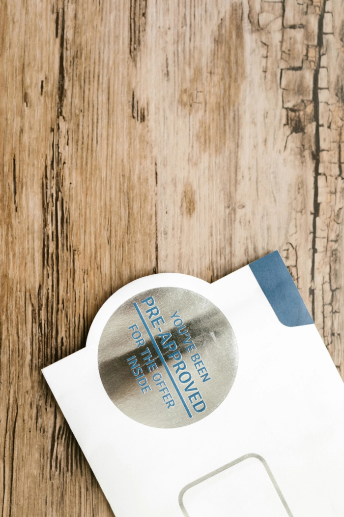 folder with a pre-approved silver card on a wooden table