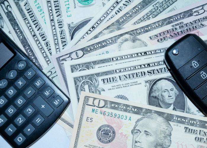 Calculator cash and a car key fob for an auto loan from Essential Credit Union