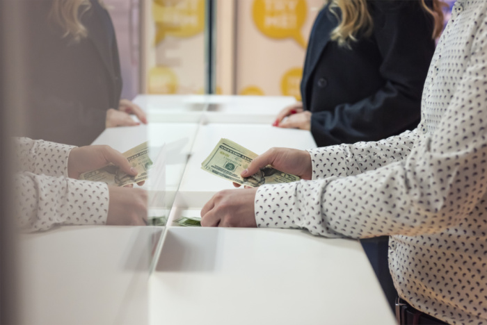 a women depositing cash into her savings account in plaquemine at essential credit union