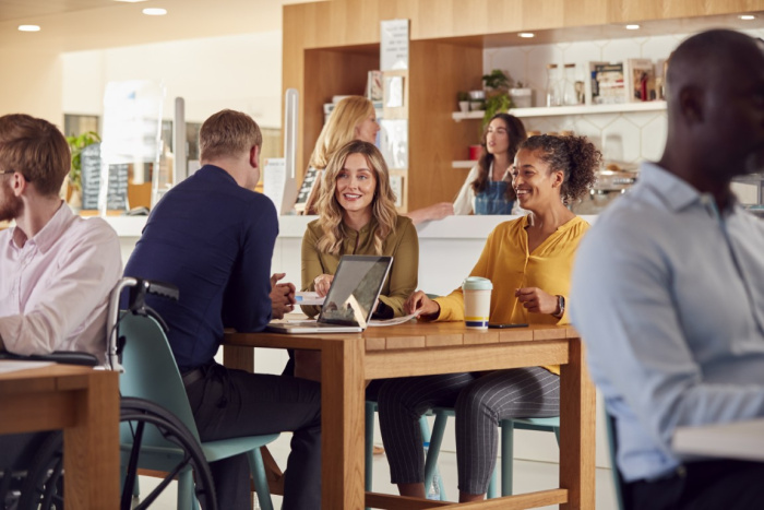 a group of colleagues having a meeting at a coffee shop in houston about money market accounts from essential credit union