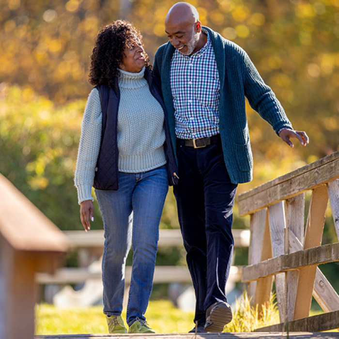 A retired couple walking on a bridge
