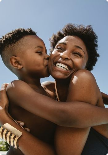 young son kissing mom on cheek